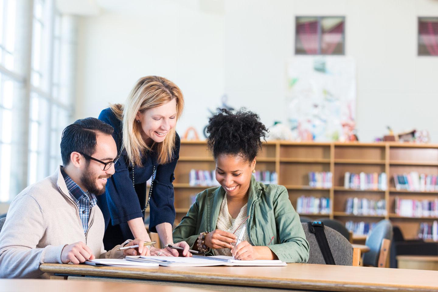 Diverse study group of adults working in large college library